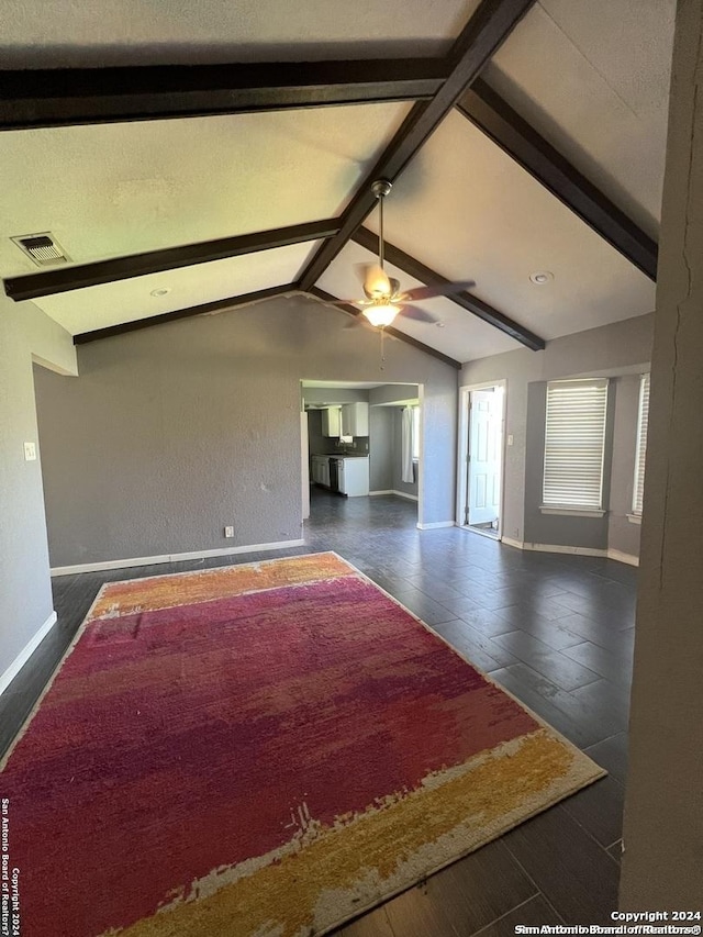 unfurnished living room with vaulted ceiling with beams and ceiling fan