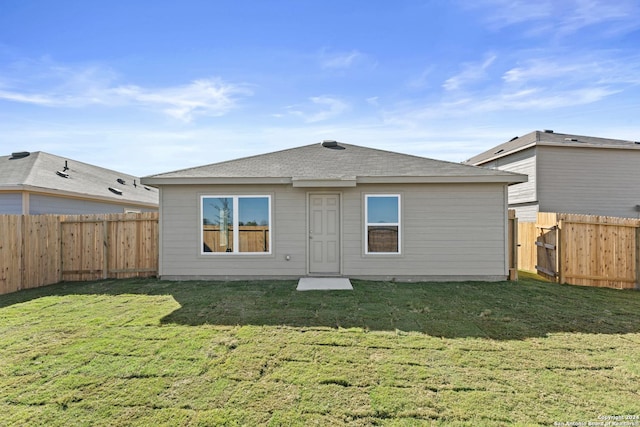 rear view of property featuring a lawn