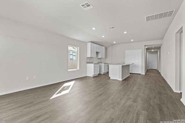 unfurnished living room with vaulted ceiling and dark hardwood / wood-style floors