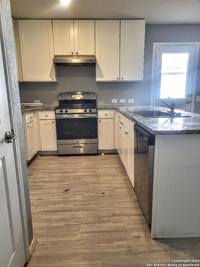 kitchen with white cabinets, light wood-type flooring, sink, and appliances with stainless steel finishes