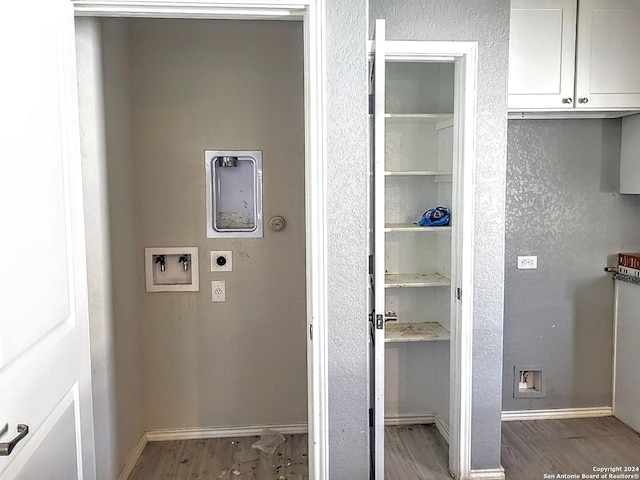 interior space featuring electric dryer hookup, cabinets, light hardwood / wood-style flooring, and washer hookup