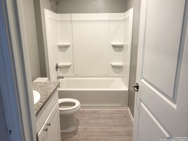 full bathroom with shower / bathing tub combination, vanity, wood-type flooring, and toilet