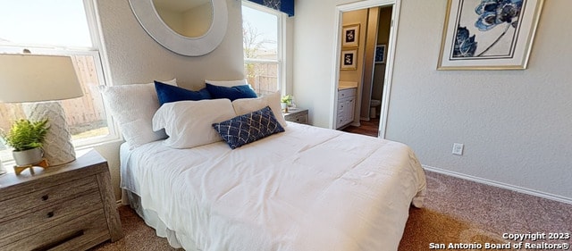 bedroom with dark colored carpet and ensuite bath