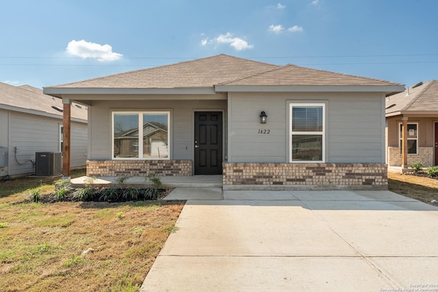view of front facade with central AC, covered porch, and a front yard
