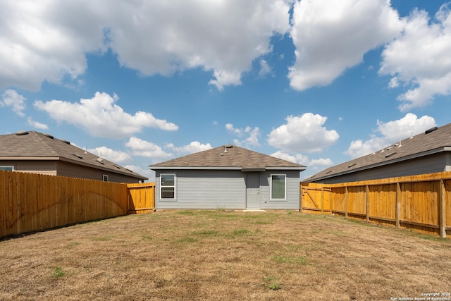 rear view of house featuring a yard