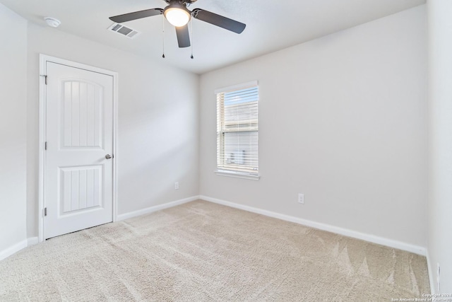 spare room with light colored carpet and ceiling fan