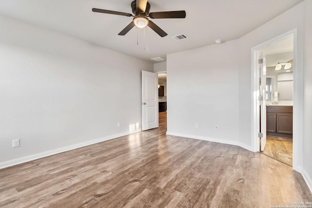 unfurnished bedroom featuring ensuite bathroom, ceiling fan, and light wood-type flooring