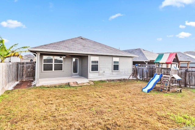 rear view of house featuring a yard and a playground