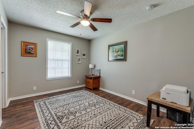 office area with ceiling fan, dark wood-type flooring, and a textured ceiling