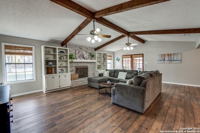 living room featuring a textured ceiling, ceiling fan, dark wood-type flooring, built in features, and a fireplace