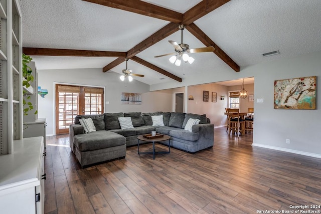 living room featuring a wealth of natural light, ceiling fan with notable chandelier, lofted ceiling with beams, and a textured ceiling