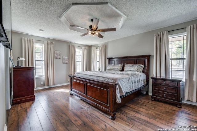 bedroom featuring ceiling fan, dark wood-type flooring, and a textured ceiling