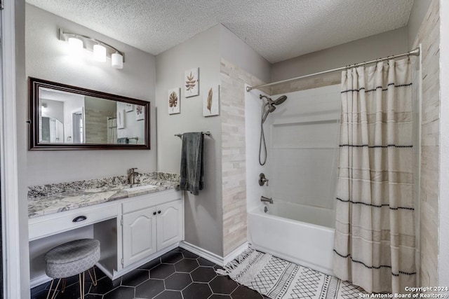 bathroom featuring tile patterned flooring, vanity, shower / bath combo with shower curtain, and a textured ceiling