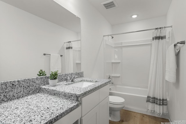 full bathroom with shower / tub combo with curtain, vanity, hardwood / wood-style floors, and toilet