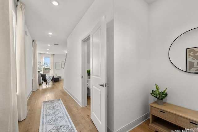 hallway with light hardwood / wood-style floors