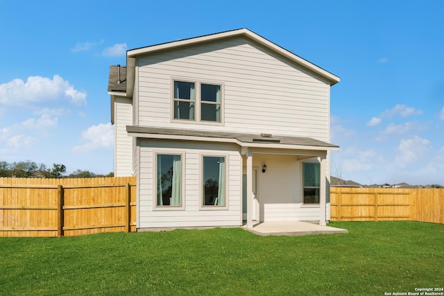 back of house with a lawn