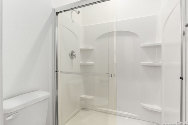 full bathroom featuring toilet and a stall shower