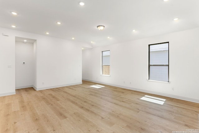 empty room with recessed lighting, light wood-type flooring, and baseboards