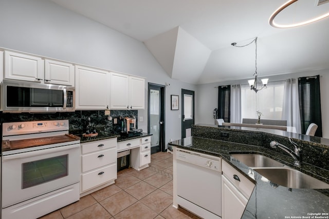 kitchen featuring white cabinets, white appliances, lofted ceiling, and backsplash