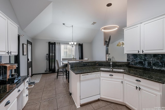 kitchen with backsplash, white cabinets, vaulted ceiling, dishwasher, and hanging light fixtures