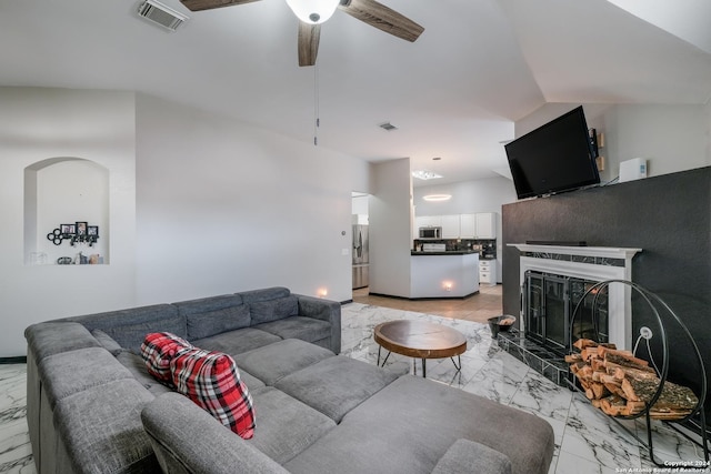 living room with ceiling fan and a high end fireplace