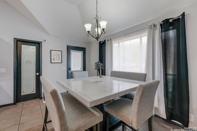 tiled dining space with a notable chandelier and vaulted ceiling