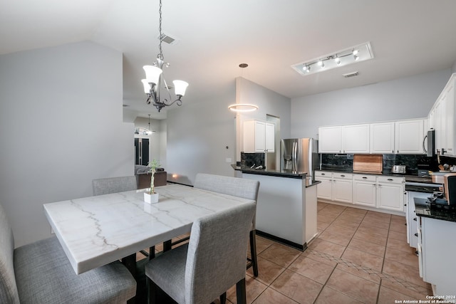 kitchen with decorative light fixtures, a center island, stainless steel appliances, and white cabinetry