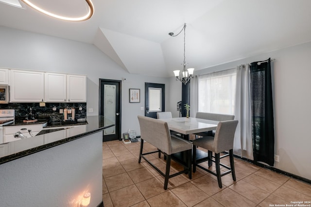 dining room featuring a notable chandelier, lofted ceiling, and light tile patterned flooring