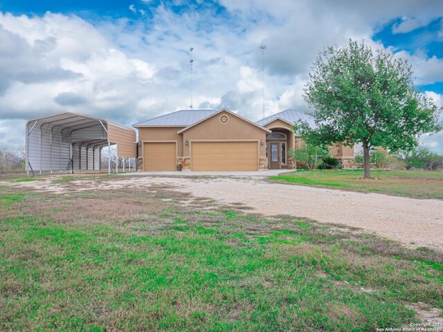 ranch-style house with a garage, a front yard, and a carport