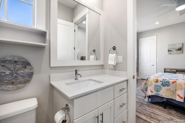 bathroom featuring wood-type flooring, vanity, toilet, and ceiling fan