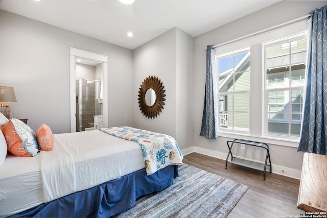 bedroom with hardwood / wood-style floors, ceiling fan, and connected bathroom