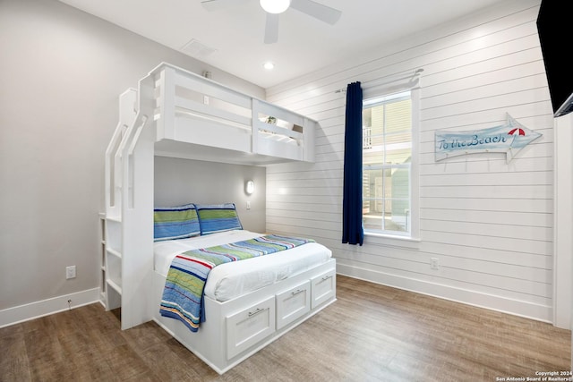 bedroom featuring multiple windows, wood-type flooring, and ceiling fan