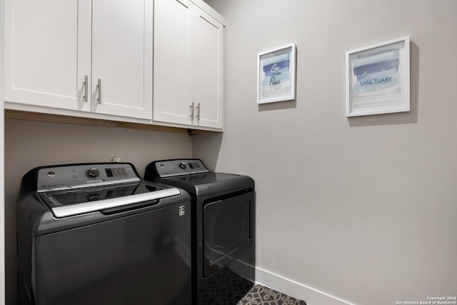 washroom with separate washer and dryer, cabinets, and dark tile patterned flooring