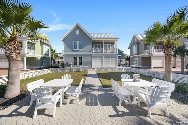 back of house featuring a lawn, a patio area, and a balcony