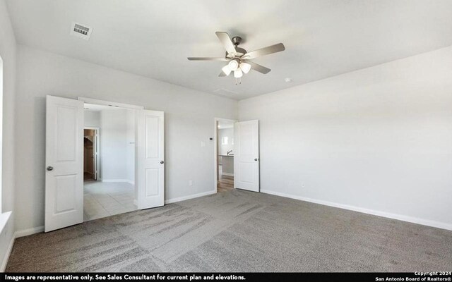 unfurnished bedroom featuring light carpet and ceiling fan