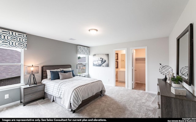 bedroom with light carpet, ensuite bathroom, a spacious closet, and a closet