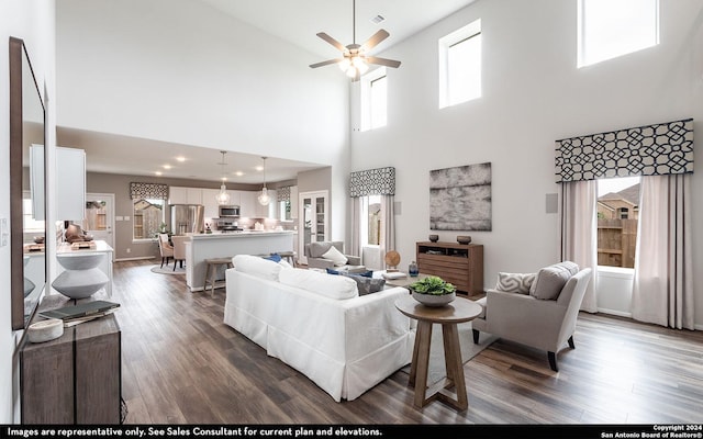 living room featuring a high ceiling, dark hardwood / wood-style floors, and ceiling fan