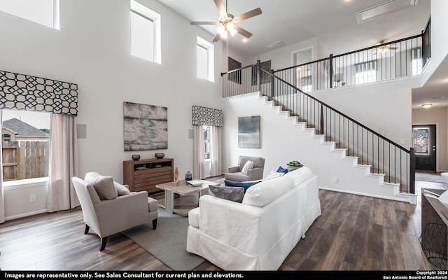 living room with hardwood / wood-style floors, a towering ceiling, a wealth of natural light, and ceiling fan