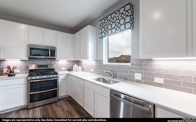 kitchen featuring sink, dark wood-type flooring, stainless steel appliances, decorative backsplash, and white cabinets