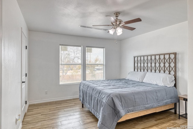 bedroom featuring a textured ceiling, light hardwood / wood-style floors, and ceiling fan