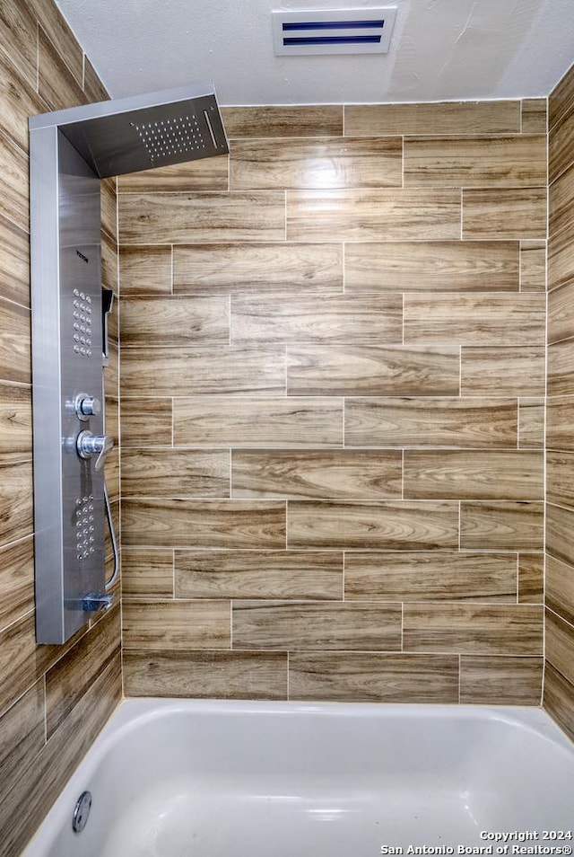 bathroom featuring tiled shower / bath