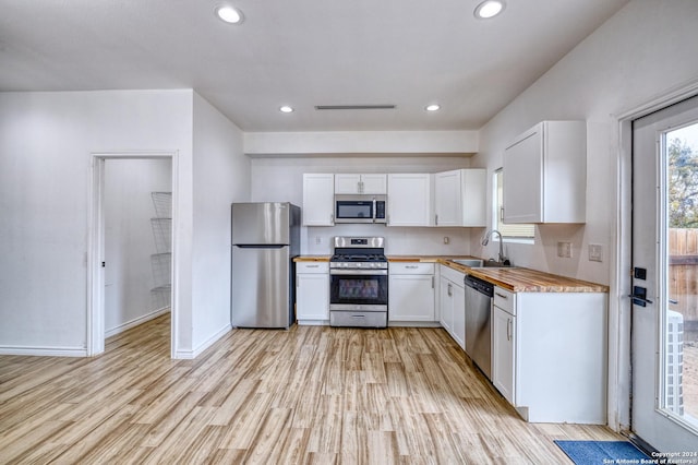 kitchen featuring white cabinetry, sink, light wood-type flooring, and appliances with stainless steel finishes