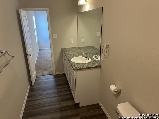 bathroom featuring wood-type flooring, vanity, and toilet