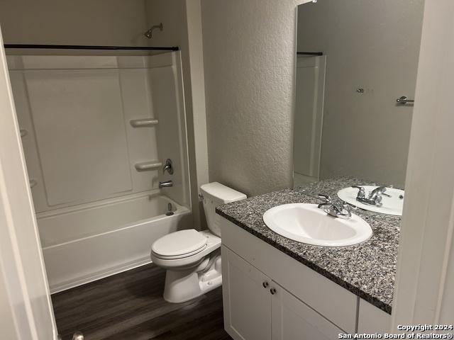 full bathroom with vanity, shower / bath combination, hardwood / wood-style flooring, and toilet