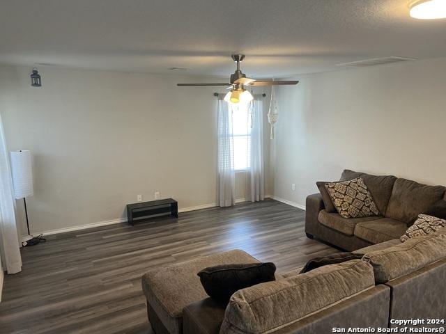 living room featuring dark hardwood / wood-style floors and ceiling fan