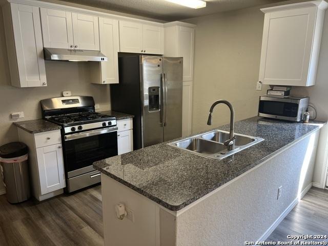 kitchen featuring white cabinets, sink, kitchen peninsula, and stainless steel appliances