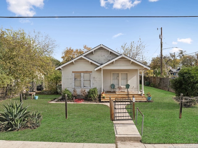 bungalow-style house featuring a front lawn, fence, and a porch