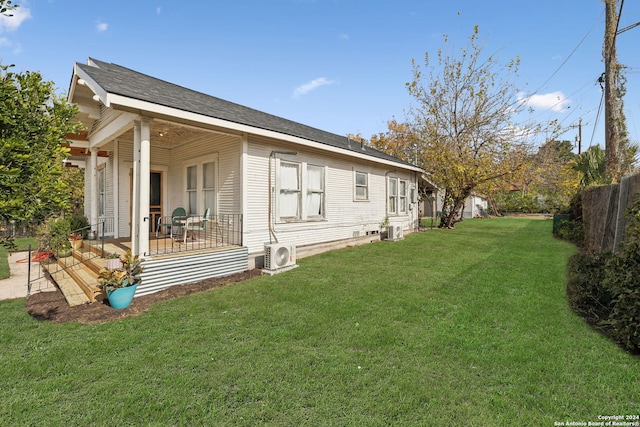 view of side of home with a lawn, ac unit, central AC unit, and covered porch