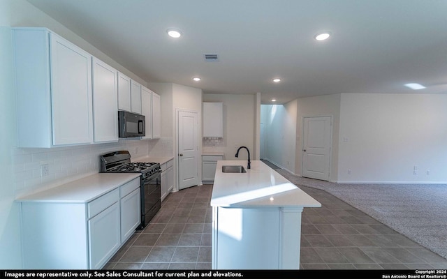 kitchen with white cabinets, sink, a kitchen island with sink, and black appliances