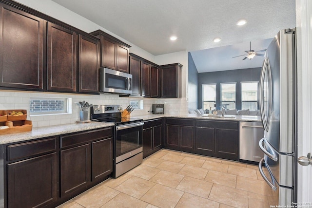 kitchen featuring backsplash, sink, a textured ceiling, appliances with stainless steel finishes, and dark brown cabinets